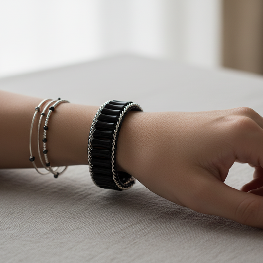 Model's wrist wearing black and silver bracelet
