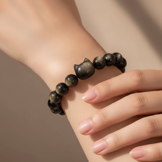 Model's wrist wearing Gold Obsidian cat bracelet